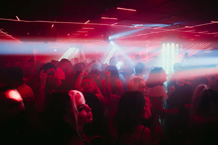 Red ceiling lights above the crowd at Radio Javan Party in Manchester